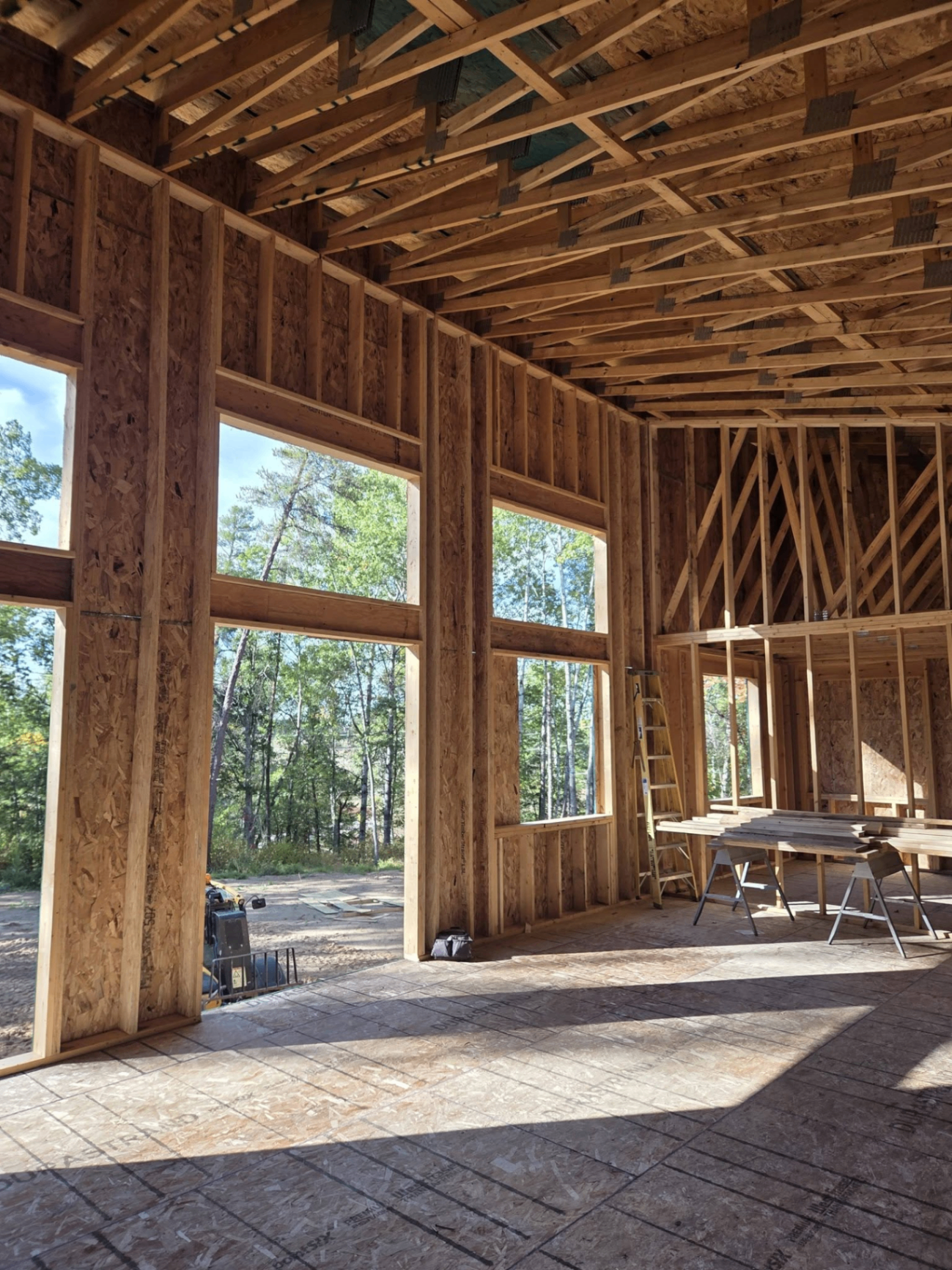 Framing stage of a custom home with tall window openings
