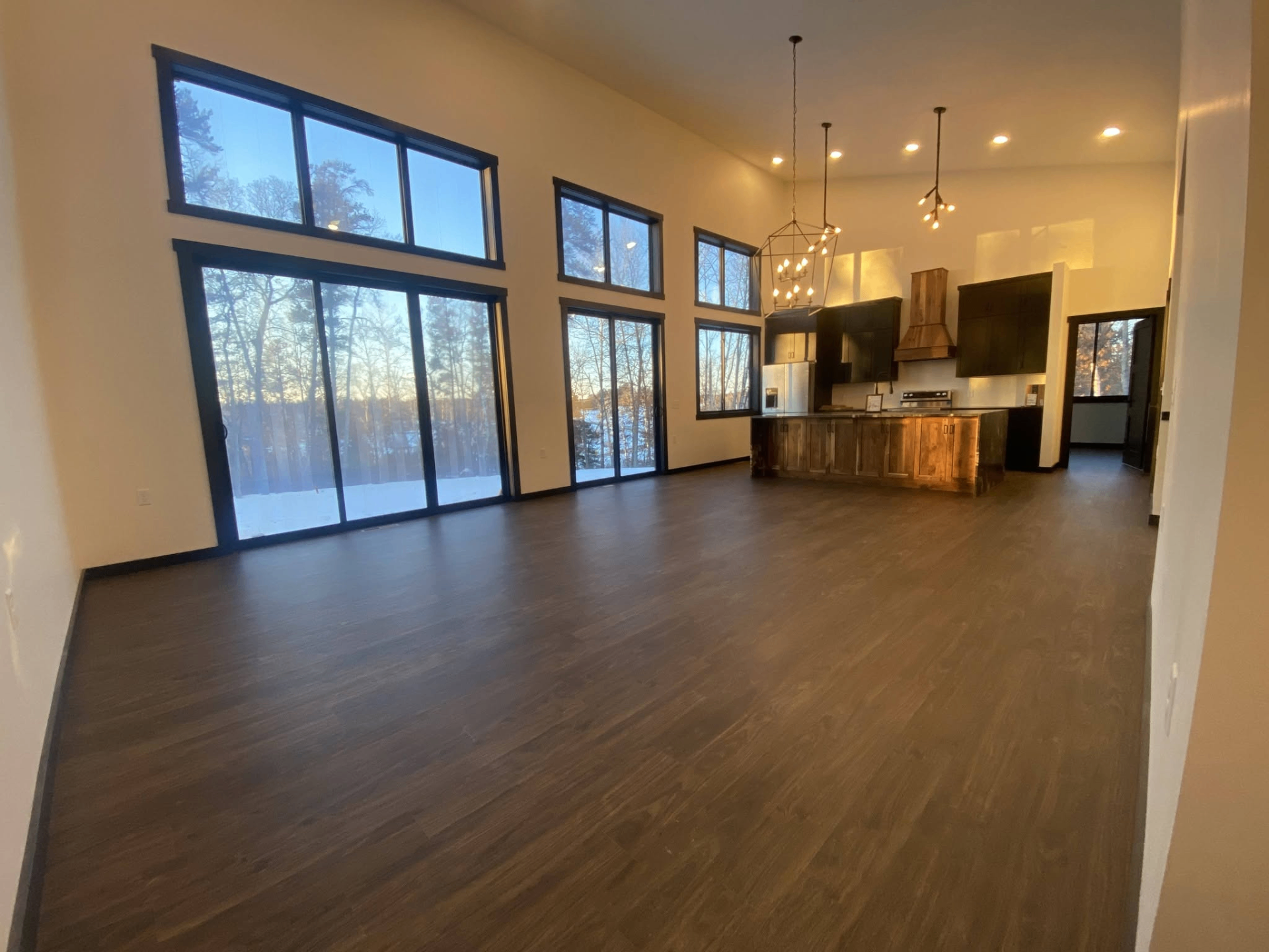Open-concept living room and kitchen with tall windows